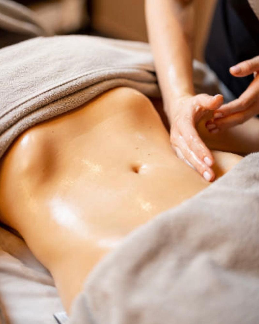 Massage van de buik met olie na een ingreep.
